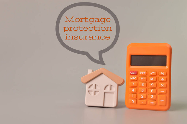テキストで書かれた計算機とおもちゃの家｜MORTGAGE Protection Insurance - 写真・画像