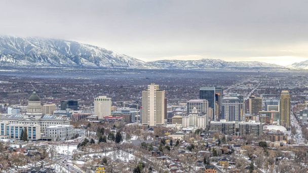 Panorama Pano de Salt Lake City con montaña nevada y cielo gris nublado en invierno - Foto, Imagen