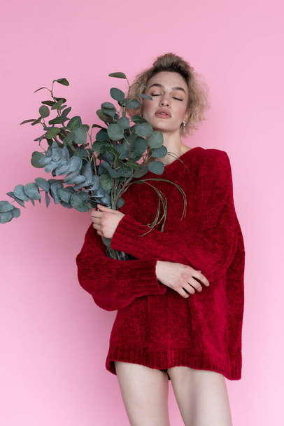 junge schöne Frau posiert im roten Pullover im Studio - Foto, Bild