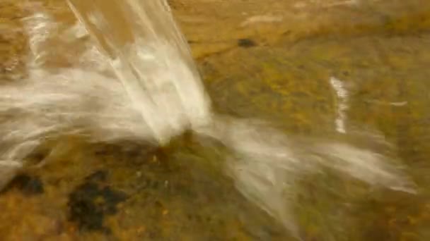 spritzendes klares Wasser aus dem Rohr läuft zu Felsbrocken hinunter und erzeugt Blasen, Tropfen, die den Abfluss bespritzen - Filmmaterial, Video