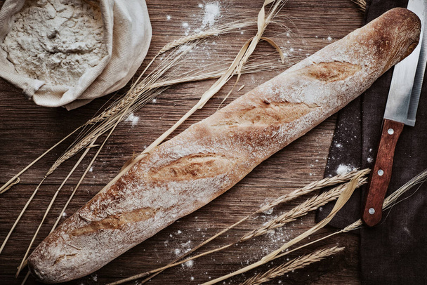 Baking, fresh bread on a wooden surface - Fotoğraf, Görsel