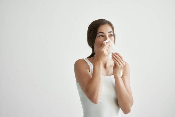 donna in una t-shirt bianca soffia il naso in un velo infezione medicina fredda - Foto, immagini