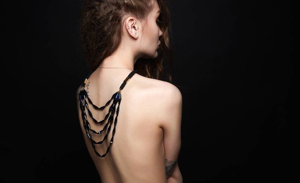 sexy female back. beautiful young woman with necklace on her naked back. curly Girl with jewelry - Photo, Image