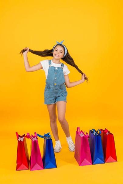 Goods for hair. Shopping day. Fashion boutique. Cheerful girl shopping. Cosmetics shop. Little girl with shopping packages. Happy child in shop with bags. Small child in summer style. Seasonal sales - Photo, image
