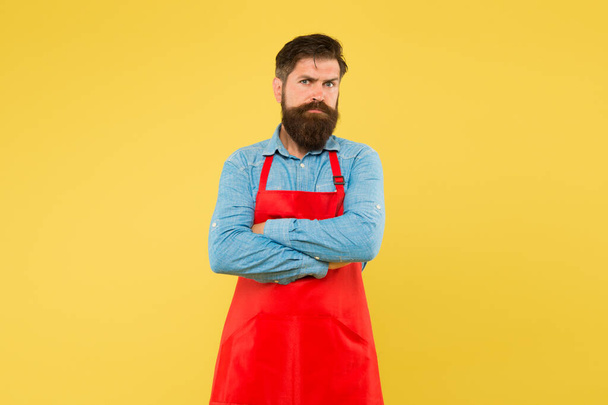 commercial kitchen. Entrepreneur in his modern look. bearded chef or waiter wearing red apron. brutal waiter or barista. Barber man in an apron with long beard. handsome confident guy master - Фото, зображення