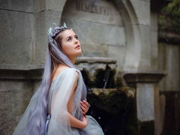 a beautiful woman like a fairy or nymph walking in the park. fairy tale image art photo. nymph of forest walk in the park - Photo, Image