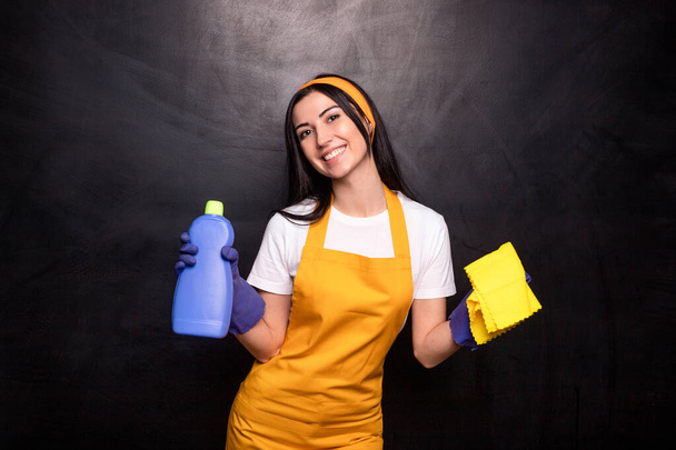 Задоволена жіноча прибиральниця з миючим засобом і тканиною
 - Фото, зображення