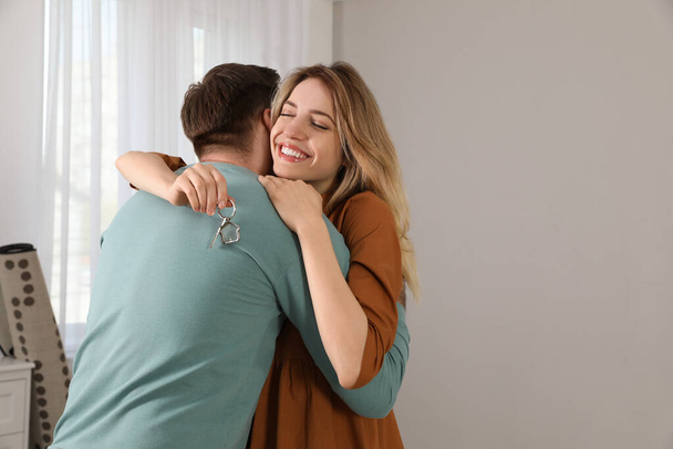 Šťastný mladý pár s klíčovým objetím v novém domě. Mezera pro text - Fotografie, Obrázek