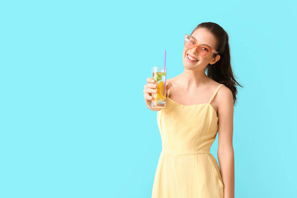 Young woman with fresh lemonade on color background - Zdjęcie, obraz