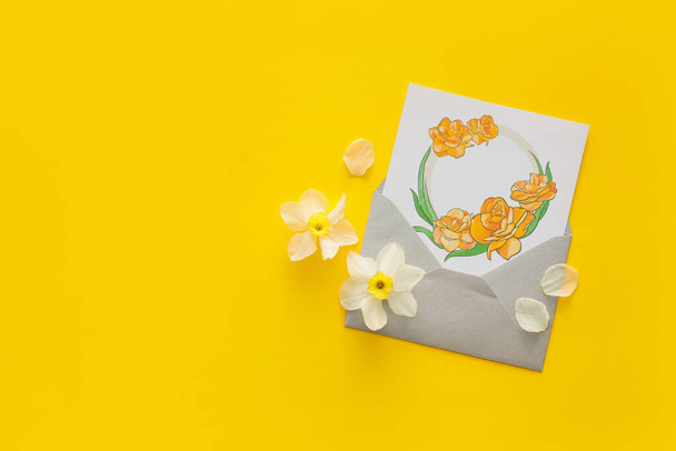 Beautiful greeting card and narcissus flowers on color background - Photo, Image