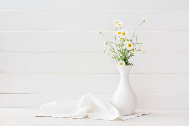 Βάζο με όμορφα λουλούδια χαμομηλιού σε ανοιχτό ξύλινο φόντο - Φωτογραφία, εικόνα