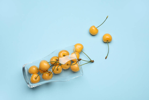 Vidrio con sabrosas cerezas dulces sobre fondo de color - Foto, Imagen
