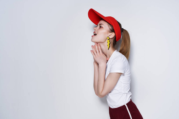 alegre chica rojo gorra moda base pendientes luz fondo - Foto, Imagen