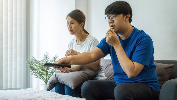 Ασιατική οικογένεια βλέποντας ταινίες στην τηλεόραση στο σπίτι το Σαββατοκύριακο. - Φωτογραφία, εικόνα