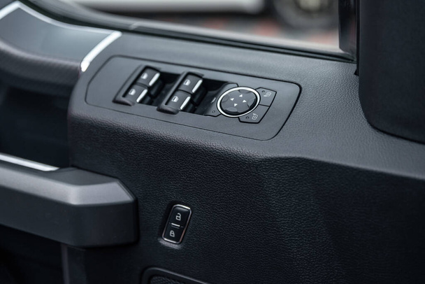 Modern bir arabanın ayna kontrol düğmesi ve pencere kontrol paneli. Otomatik araba pencere kontrolleri ve detaylar. Araba kapısı kilidi açma düğmesi. Seçici odak - Fotoğraf, Görsel