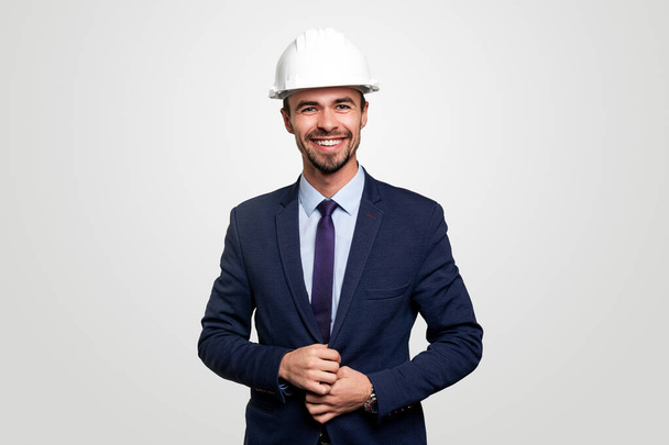 Smiling businessman in suit and hardhat - 写真・画像