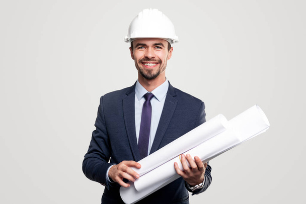 Friendly male contractor with blueprints - Foto, afbeelding