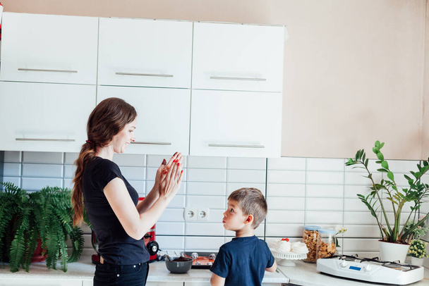 madre e hijo cocinan pasteles dulces en la cocina - Foto, Imagen