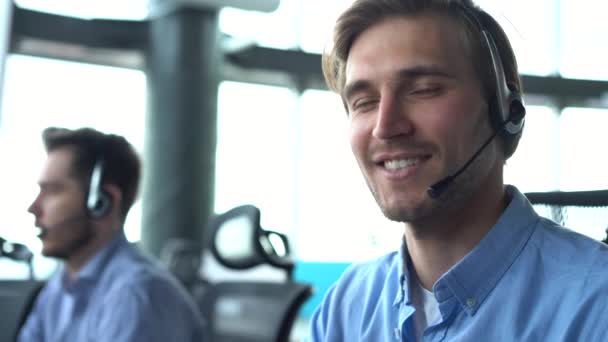 Male call center agent in headset helping client in customer support service - Filmmaterial, Video