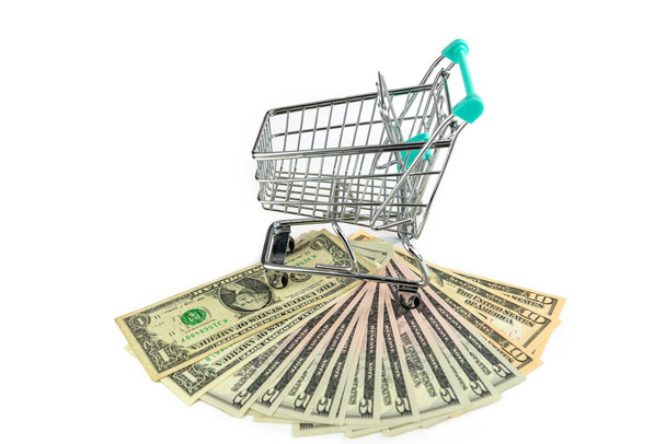 shopping trolley and US dollar banknotes isolated on white background, commerce concept - 写真・画像