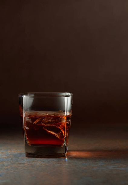 Glass of whiskey with natural ice. Rough rusty background. Copy space. - Foto, Imagen
