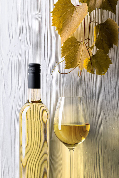 White wine and grapevine on a white wooden background. Copy space. - Foto, afbeelding