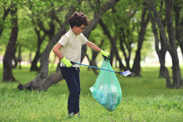 ゴミゴミのリサイクルゴミゴミゴミのクリーントレーニング。自然清掃ボランティア生態緑のコンセプト。若い男性と男の子は日没時に春の森を拾う。環境プラスチック汚染 - 写真・画像