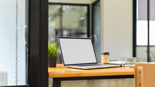 コンピュータのラップトップは、背景にぼやけたオフィスのインテリアとイメージの空白の画面の概念をモック  - 写真・画像