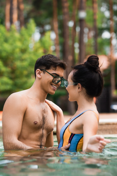 Young couple smiling in swimming pool during weekend  - Foto, immagini