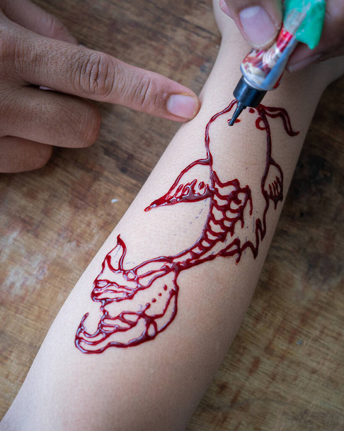Pittura ornamenti di hennè sulla mano della ragazza primo piano. - Foto, immagini