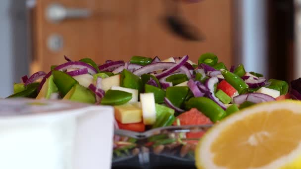 A woman prepares a larges salad with fruits, nuts and vegetables. - Metraje, vídeo