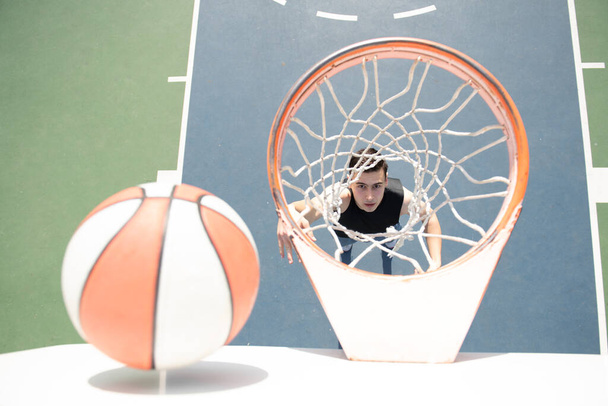 Basketball player. Sports and basketball. Man jumps and throws a ball into the basket. - Valokuva, kuva