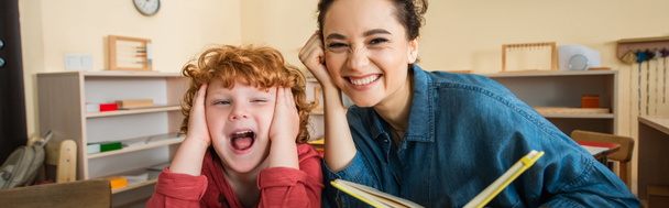 joyeux enseignant tenant livre près rousse garçon étonné, bannière - Photo, image