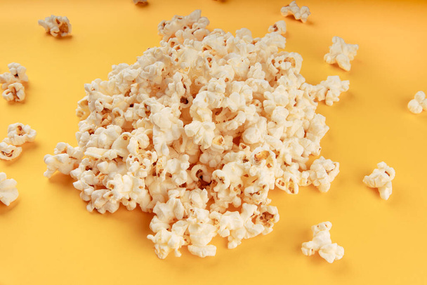 Witte popcorn op een gele achtergrond - Foto, afbeelding