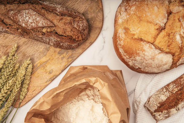 Chleb rzemieślniczy ze zbożem pszennym na kamiennym stole - Zdjęcie, obraz
