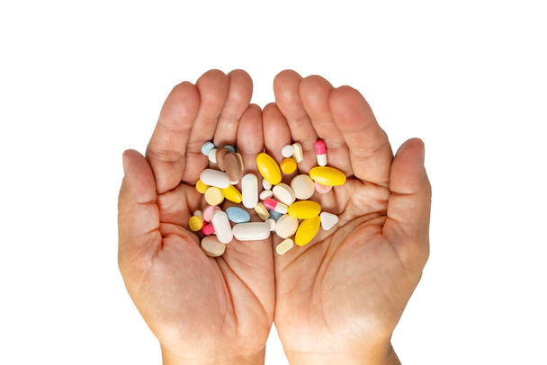 Foto der Patientin, die eine bunte Pillen in ihren Händen auf isoliertem weißem Hintergrund zeigt. - Foto, Bild