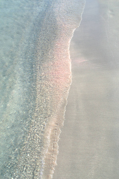 Růžový písek na písečné pláži a modrá voda. - Fotografie, Obrázek