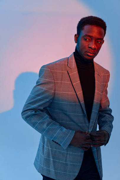 hombre de aspecto africano guapo en traje de fondo de neón de moda - Foto, Imagen