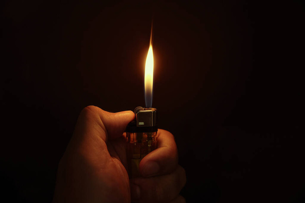 Lighter in the hand on black background - Foto, Imagem