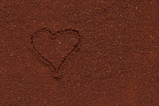 Ground coffee with heart pattern. The texture of the ground coffee.  - Foto, Bild