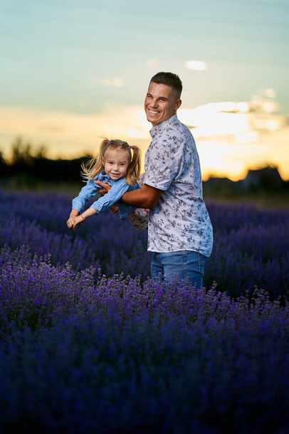Young father and toddler daughter having fun in a lavender field in full bloom - Foto, afbeelding
