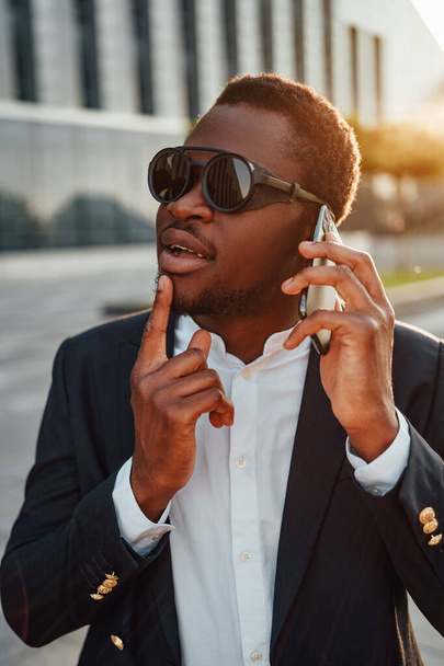 Cool persona de negocios de ascendencia africana con teléfono - Foto, imagen