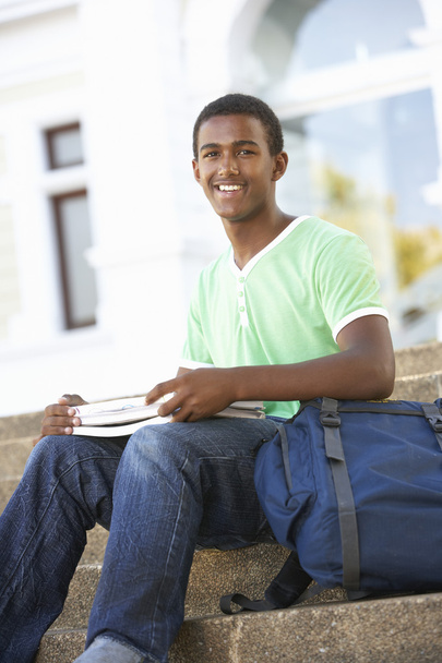 Male Teenage Student Sitting Outside On College Steps - Foto, imagen