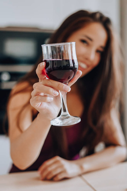 asian woman drinking wine in the kitchen at home - Foto, Imagem