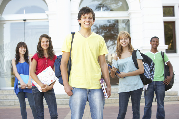 Group Of Teenage Students Standing Outside College Building - 写真・画像