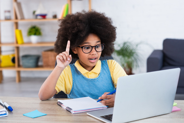Afroamerikanisches Kind hat Idee während des Unterrichts am Laptop zu Hause  - Foto, Bild