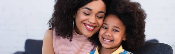African american mother smiling with closed eyes near child, banner  - Foto, immagini
