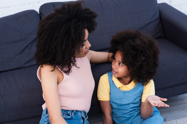 Vysoký úhel pohledu na mladé africké americké matky mluví s dcerou ukazuje rukou doma  - Fotografie, Obrázek