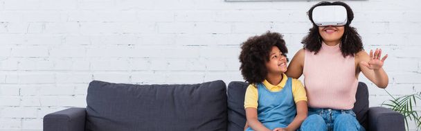 Mosolygó afro-amerikai gyerek néz anya vr headset otthon, banner  - Fotó, kép