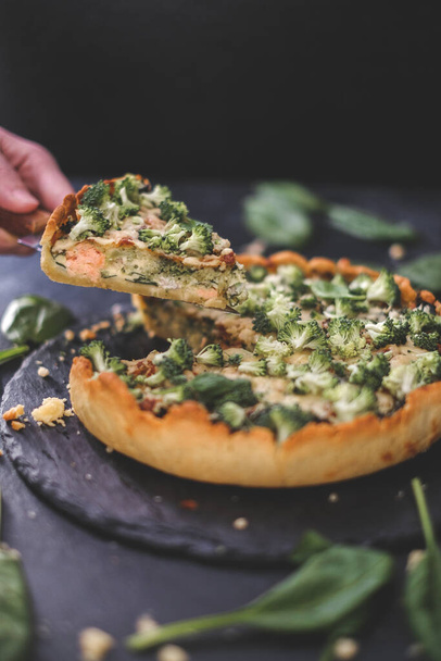 Millet quiche with spinach, salmon, broccoli and ricotta on dark wooden table. Homemade vegetarian cake. Copy space for text. Fresh pie with soft cheese. Healthy food. French cuisine - Foto, Bild